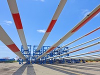 Blades of offshore wind turbines are waiting to be loaded at Penglai Port area of Yantai Port in Yantai, China, on July 31, 2024. On July 31...