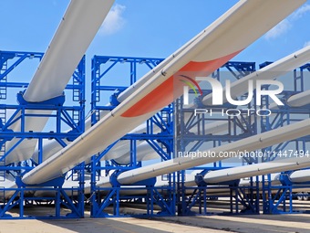 Blades of offshore wind turbines are waiting to be loaded at Penglai Port area of Yantai Port in Yantai, China, on July 31, 2024. On July 31...