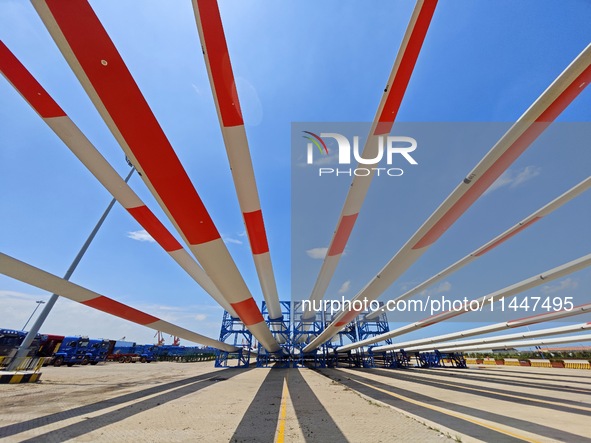 Blades of offshore wind turbines are waiting to be loaded at Penglai Port area of Yantai Port in Yantai, China, on July 31, 2024. On July 31...