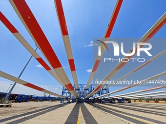 Blades of offshore wind turbines are waiting to be loaded at Penglai Port area of Yantai Port in Yantai, China, on July 31, 2024. On July 31...