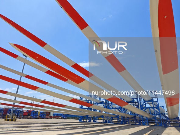 Blades of offshore wind turbines are waiting to be loaded at Penglai Port area of Yantai Port in Yantai, China, on July 31, 2024. On July 31...