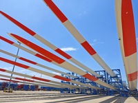 Blades of offshore wind turbines are waiting to be loaded at Penglai Port area of Yantai Port in Yantai, China, on July 31, 2024. On July 31...