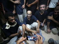 Men who are being detained by Israel during the military operation in Gaza are reacting after their release at the Aqsa Martyrs Hospital in...