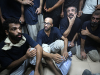 Men who are being detained by Israel during the military operation in Gaza are reacting after their release at the Aqsa Martyrs Hospital in...