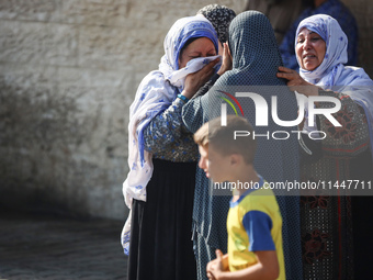 Palestinians are mourning over the bodies of loved ones  following Israeli bombardment in Deir el-Balah in the central Gaza Strip on August...