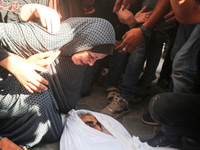 Palestinians are mourning over the bodies of loved ones  following Israeli bombardment in Deir el-Balah in the central Gaza Strip on August...