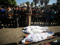 Palestinian men are praying over victims killed in an Israeli strike at the Aqsa Martyrs hospital in Deir el-Balah, on August 1, 2024, amid...