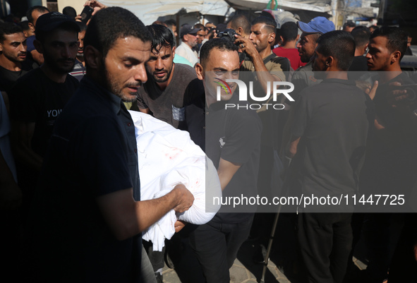 Palestinian men are praying over victims killed in an Israeli strike at the Aqsa Martyrs hospital in Deir el-Balah, on August 1, 2024, amid...