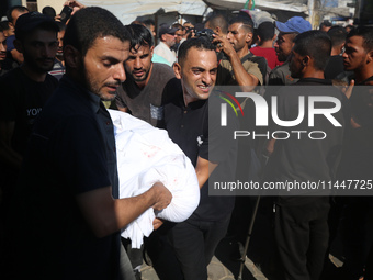 Palestinian men are praying over victims killed in an Israeli strike at the Aqsa Martyrs hospital in Deir el-Balah, on August 1, 2024, amid...