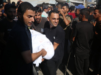 Palestinian men are praying over victims killed in an Israeli strike at the Aqsa Martyrs hospital in Deir el-Balah, on August 1, 2024, amid...