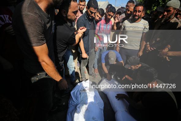 Palestinian men are praying over victims killed in an Israeli strike at the Aqsa Martyrs hospital in Deir el-Balah, on August 1, 2024, amid...