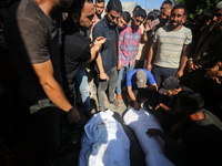 Palestinian men are praying over victims killed in an Israeli strike at the Aqsa Martyrs hospital in Deir el-Balah, on August 1, 2024, amid...