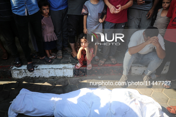 Palestinian men are praying over victims killed in an Israeli strike at the Aqsa Martyrs hospital in Deir el-Balah, on August 1, 2024, amid...