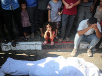 Palestinian men are praying over victims killed in an Israeli strike at the Aqsa Martyrs hospital in Deir el-Balah, on August 1, 2024, amid...