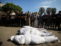 Palestinian men are praying over victims killed in an Israeli strike at the Aqsa Martyrs hospital in Deir el-Balah, on August 1, 2024, amid...