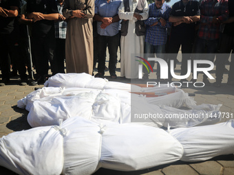 Palestinian men are praying over victims killed in an Israeli strike at the Aqsa Martyrs hospital in Deir el-Balah, on August 1, 2024, amid...