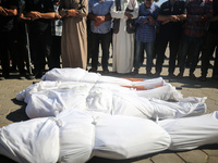 Palestinian men are praying over victims killed in an Israeli strike at the Aqsa Martyrs hospital in Deir el-Balah, on August 1, 2024, amid...