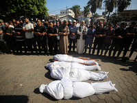 Palestinian men are praying over victims killed in an Israeli strike at the Aqsa Martyrs hospital in Deir el-Balah, on August 1, 2024, amid...