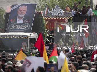 A truck is carrying the coffins containing the bodies of Hamas leader Ismail Haniyeh and his bodyguard Abu Shaaban through the crowd during...