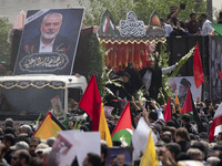 A truck is carrying the coffins containing the bodies of Hamas leader Ismail Haniyeh and his bodyguard Abu Shaaban through the crowd during...