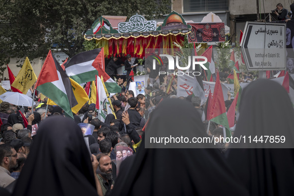 A truck is carrying the coffins containing the bodies of Hamas leader Ismail Haniyeh and his bodyguard Abu Shaaban through the crowd during...