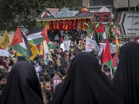 A truck is carrying the coffins containing the bodies of Hamas leader Ismail Haniyeh and his bodyguard Abu Shaaban through the crowd during...