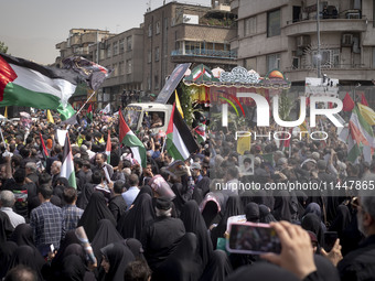 A truck is carrying the coffins containing the bodies of Hamas leader Ismail Haniyeh and his bodyguard Abu Shaaban through the crowd during...