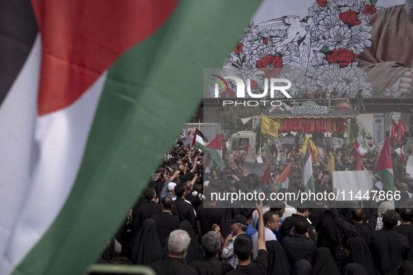 A truck is carrying the coffins containing the bodies of Hamas leader Ismail Haniyeh and his bodyguard Abu Shaaban through the crowd during...