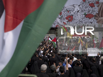 A truck is carrying the coffins containing the bodies of Hamas leader Ismail Haniyeh and his bodyguard Abu Shaaban through the crowd during...