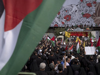 A truck is carrying the coffins containing the bodies of Hamas leader Ismail Haniyeh and his bodyguard Abu Shaaban through the crowd during...