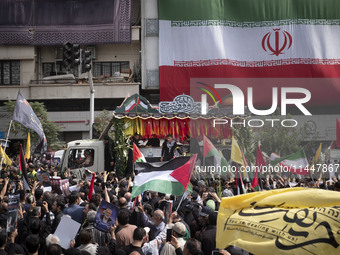 A truck is carrying the coffins containing the bodies of Hamas leader Ismail Haniyeh and his bodyguard Abu Shaaban through the crowd during...