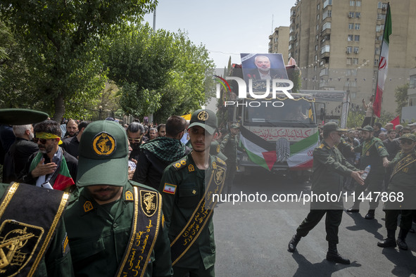 The Islamic Revolutionary Guard Corps (IRGC) military personnel are making way for the truck that is carrying the coffins containing the bod...