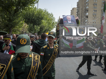 The Islamic Revolutionary Guard Corps (IRGC) military personnel are making way for the truck that is carrying the coffins containing the bod...