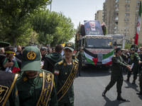 The Islamic Revolutionary Guard Corps (IRGC) military personnel are making way for the truck that is carrying the coffins containing the bod...