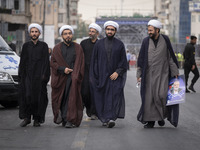 Iranian clerics are walking together along an avenue while one of them is carrying a portrait of Hamas leader Ismail Haniyeh, during a funer...