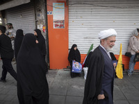 A veiled Iranian woman is holding a portrait of Hamas leader Ismail Haniyeh during a funeral ceremony for him and his bodyguard Abu Shaaban...