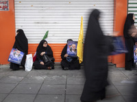 Veiled Iranian women are holding portraits of Hamas leader Ismail Haniyeh during a funeral ceremony for him and his bodyguard Abu Shaaban in...