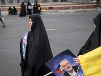 Two veiled Iranian women are carrying portraits of Hamas leader Ismail Haniyeh during a funeral ceremony for him and his bodyguard Abu Shaab...