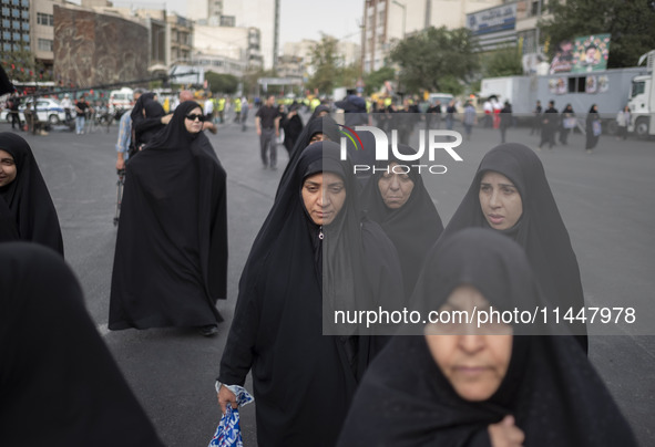 A group of veiled Iranian women is walking along an avenue during a funeral ceremony for Hamas Leader Ismail Haniyeh and his bodyguard Abu S...