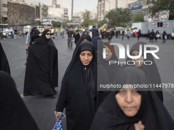 A group of veiled Iranian women is walking along an avenue during a funeral ceremony for Hamas Leader Ismail Haniyeh and his bodyguard Abu S...