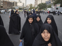 A group of veiled Iranian women is walking along an avenue during a funeral ceremony for Hamas Leader Ismail Haniyeh and his bodyguard Abu S...