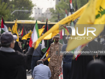 An Islamic Revolutionary Guard Corps (IRGC) military personnel is monitoring people during a funeral ceremony for Hamas leader Ismail Haniye...