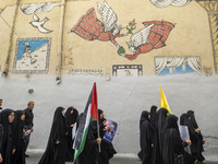 Iranian mourners are walking under a mural while one of them is carrying a Palestinian flag and a portrait of Hamas leader Ismail Haniyeh du...