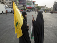 Two veiled Iranian women are holding a Lebanon's Hezbollah flag and a Palestinian flag during a funeral ceremony for Hamas leader Ismail Han...