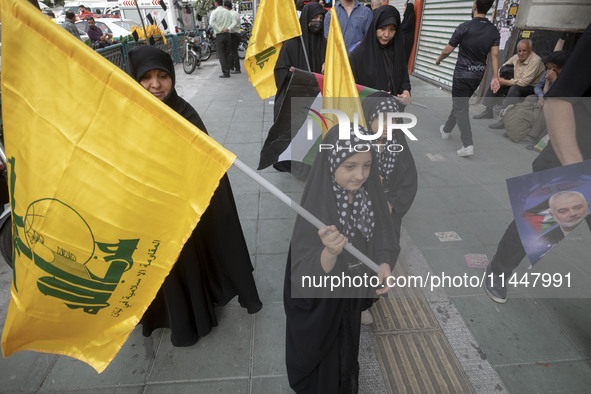 Young veiled Iranian girls are carrying Lebanon's Hezbollah flags during a funeral ceremony for Hamas leader Ismail Haniyeh and his bodyguar...