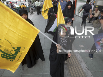 Young veiled Iranian girls are carrying Lebanon's Hezbollah flags during a funeral ceremony for Hamas leader Ismail Haniyeh and his bodyguar...