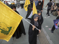 Young veiled Iranian girls are carrying Lebanon's Hezbollah flags during a funeral ceremony for Hamas leader Ismail Haniyeh and his bodyguar...