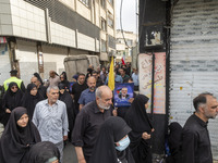 An Iranian man is carrying a portrait of Hamas leader Ismail Haniyeh during a funeral ceremony for him and his bodyguard Abu Shaaban in Tehr...