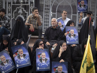 Iranian mourners are holding portraits of Hamas leader Ismail Haniyeh during a funeral ceremony for him and his bodyguard Abu Shaaban in Teh...