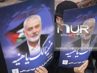 Iranian mourners are holding portraits of Hamas leader Ismail Haniyeh during a funeral ceremony for him and his bodyguard Abu Shaaban in Teh...